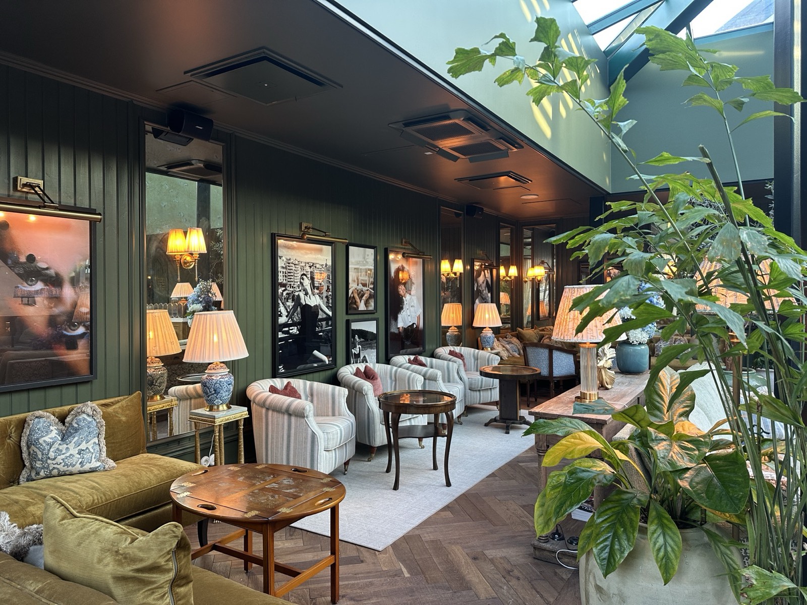 Green lounge with velvet armchairs and a garden view