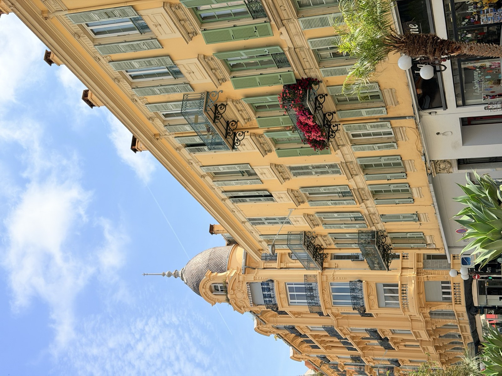 Yellow Belle Époque building with green shutters