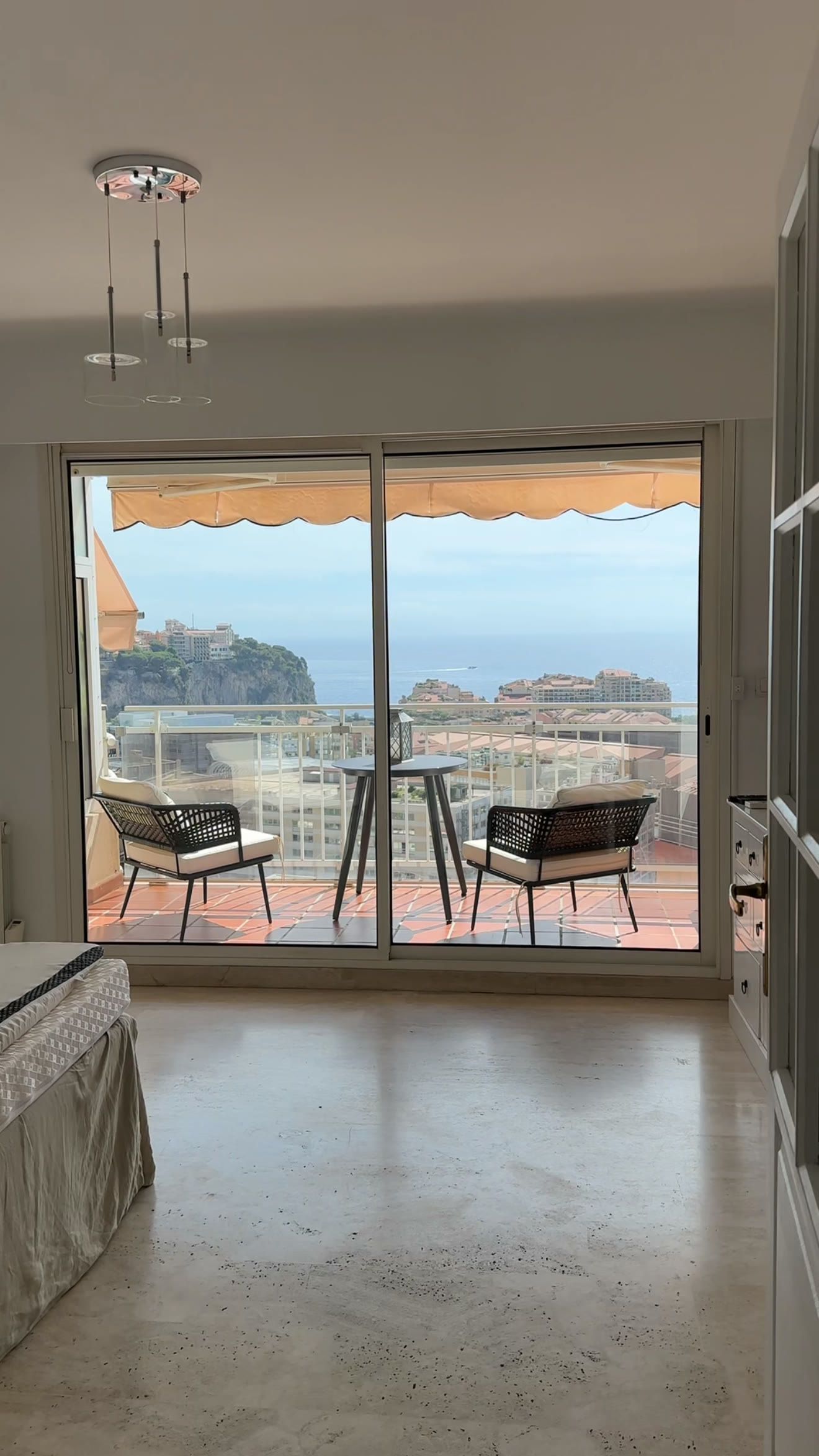 Bright room opening onto a balcony with a sea view